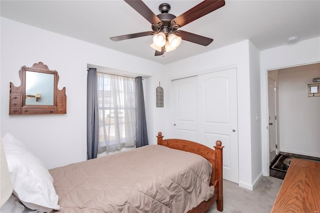 bedroom with a ceiling fan, carpet, a closet, and baseboards