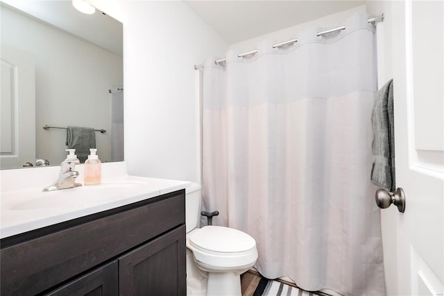 bathroom with a shower with shower curtain, vanity, and toilet