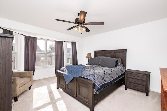 bedroom featuring a ceiling fan, light colored carpet, and baseboards