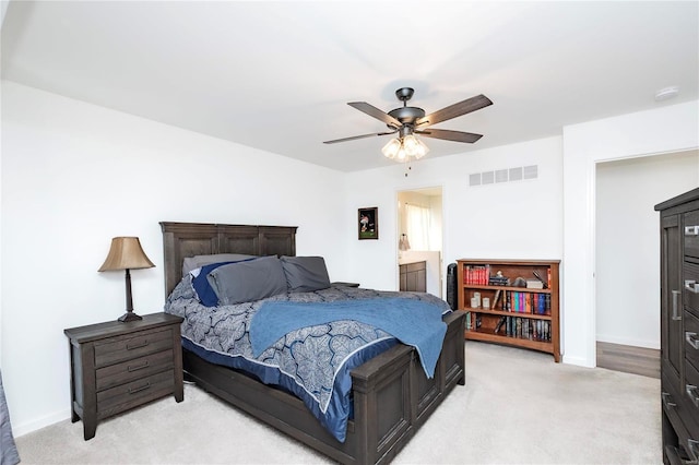 bedroom featuring light carpet, baseboards, visible vents, and a ceiling fan