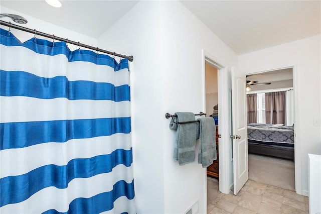 ensuite bathroom featuring a shower with curtain, visible vents, and connected bathroom