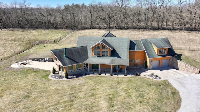 view of front facade with driveway, a garage, a porch, fence, and a front lawn