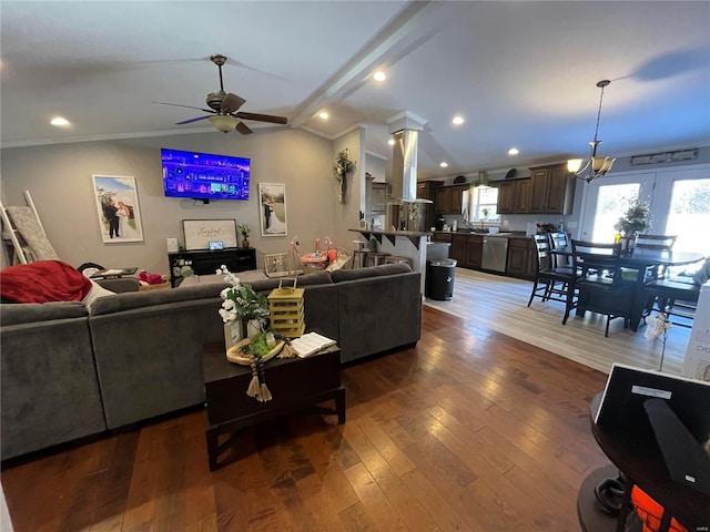 living area featuring lofted ceiling, hardwood / wood-style flooring, recessed lighting, a ceiling fan, and decorative columns