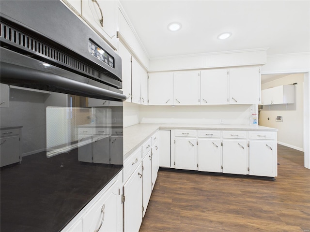 kitchen with dark wood-type flooring, recessed lighting, white cabinets, and crown molding