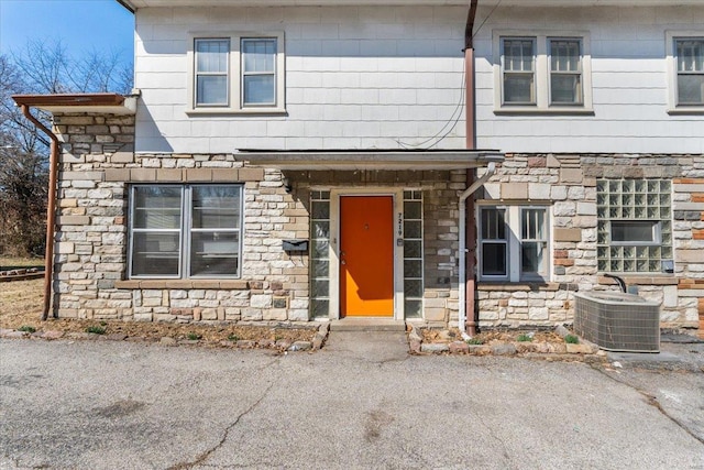 view of front of house with stone siding and central AC unit