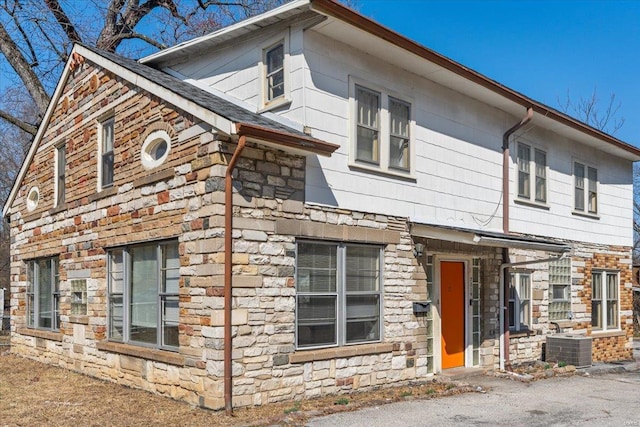 view of front of property with stone siding and cooling unit