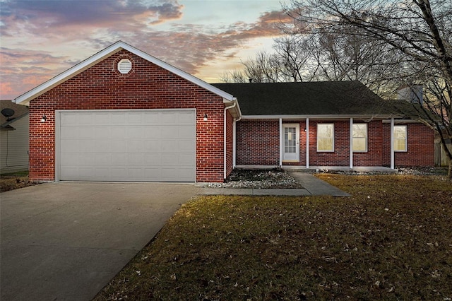 ranch-style home featuring a yard, brick siding, driveway, and an attached garage