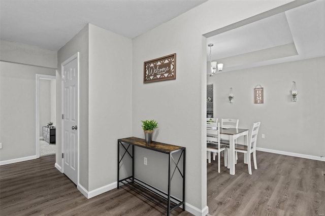 dining area with an inviting chandelier, baseboards, and wood finished floors