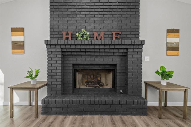 details with a fireplace, baseboards, and wood finished floors