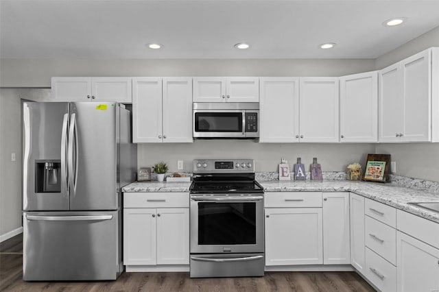 kitchen featuring white cabinets, dark wood-style floors, stainless steel appliances, and light stone countertops