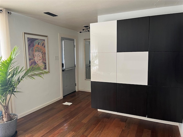 interior space with baseboards and dark wood-style flooring