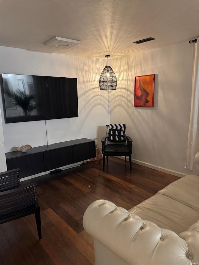 living area with visible vents, baseboards, and wood finished floors