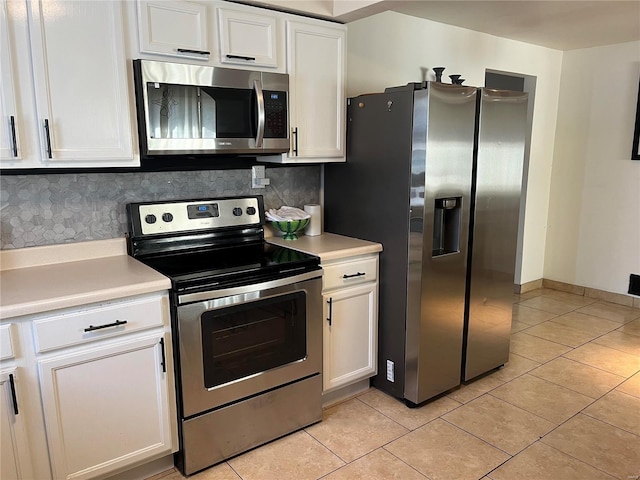 kitchen featuring appliances with stainless steel finishes, white cabinets, light tile patterned flooring, and light countertops