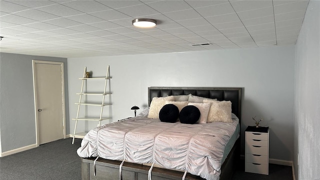 bedroom featuring dark colored carpet, visible vents, and baseboards