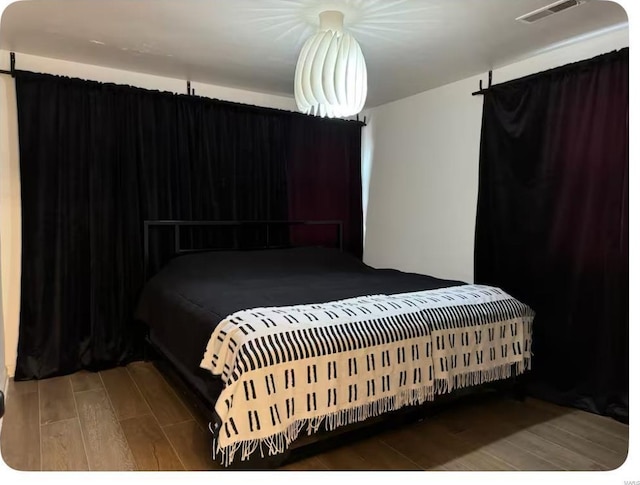 bedroom featuring visible vents and wood finished floors