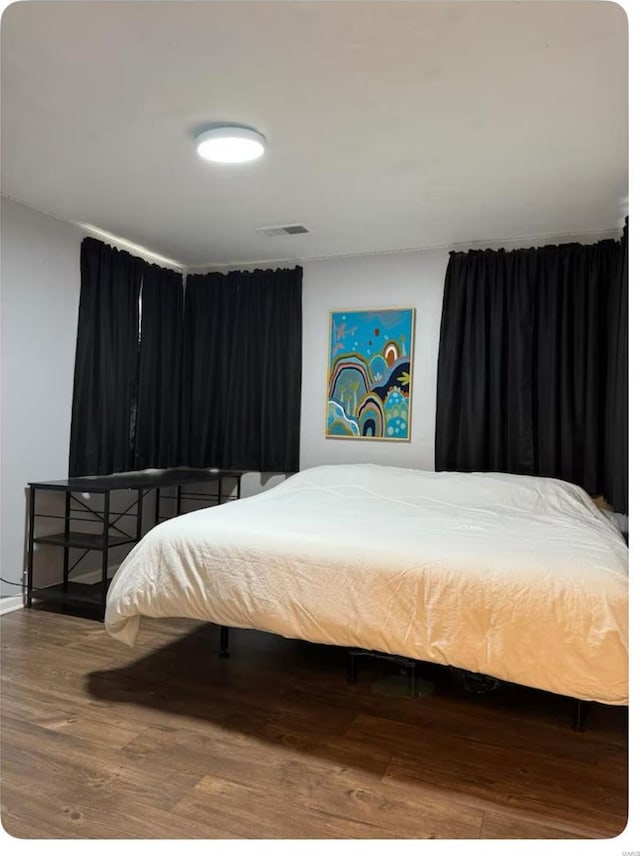 bedroom featuring visible vents and wood finished floors