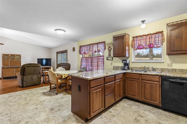 kitchen featuring a peninsula, a sink, vaulted ceiling, light stone countertops, and dishwasher