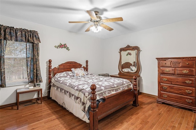 bedroom featuring light wood finished floors, baseboards, and a ceiling fan