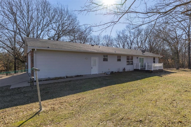 rear view of house with a deck and a lawn