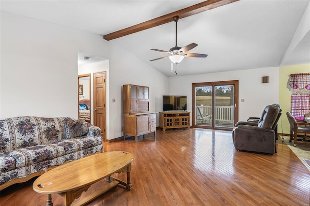 living area with a ceiling fan, lofted ceiling with beams, baseboards, and wood finished floors