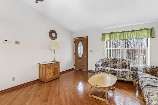 living area with lofted ceiling, baseboards, and hardwood / wood-style flooring