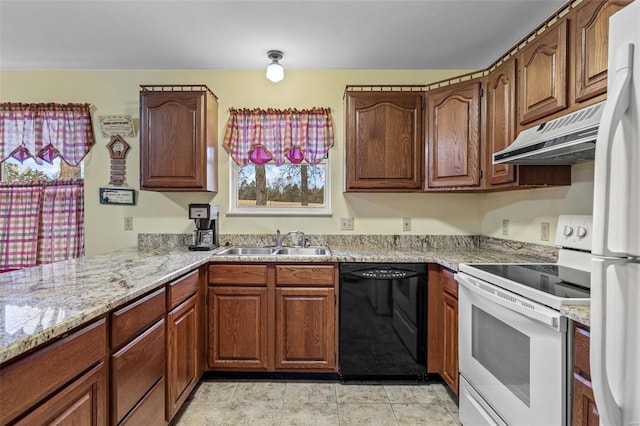 kitchen with a sink, a peninsula, light stone countertops, white appliances, and under cabinet range hood