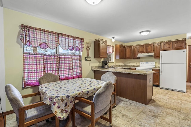 kitchen featuring white appliances, a peninsula, light countertops, under cabinet range hood, and a sink