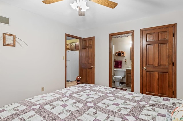 bedroom featuring ceiling fan, visible vents, ensuite bathroom, and freestanding refrigerator