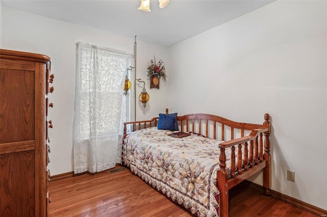 bedroom with baseboards and wood finished floors