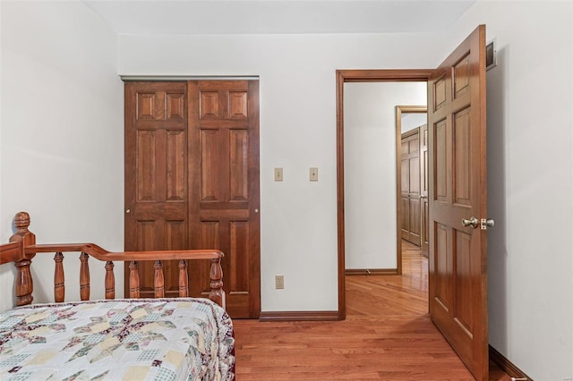 bedroom with light wood-style flooring, visible vents, and baseboards