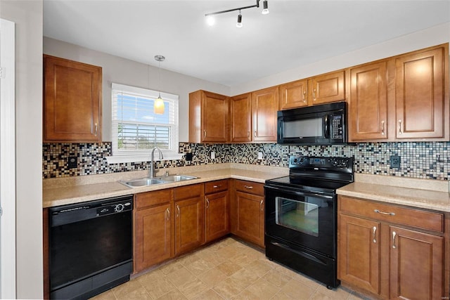 kitchen featuring brown cabinetry, a sink, decorative backsplash, black appliances, and light countertops