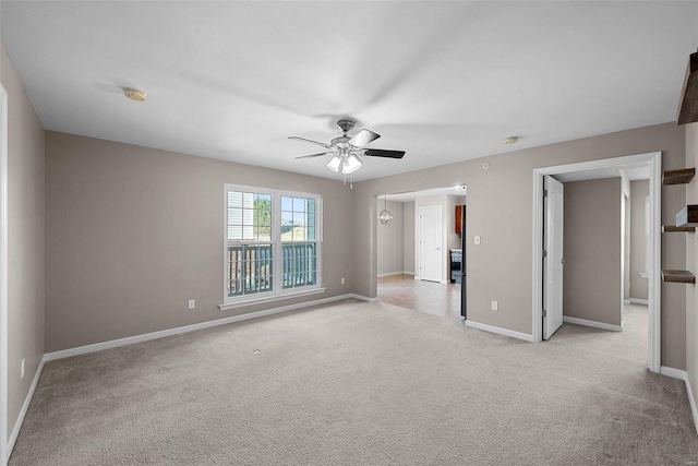 spare room featuring baseboards, light colored carpet, and a ceiling fan