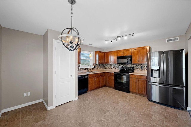 kitchen with a sink, visible vents, black appliances, and light countertops