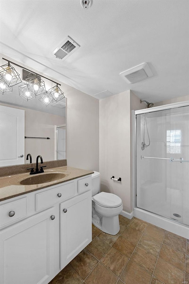 bathroom featuring visible vents, a shower stall, toilet, and vanity