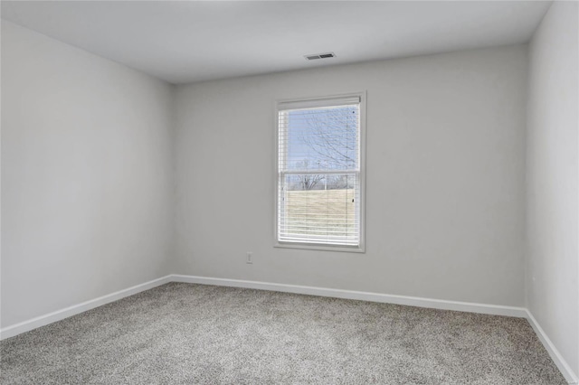 unfurnished room with carpet, visible vents, and baseboards