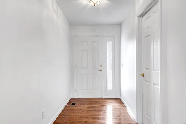 foyer featuring wood finished floors, visible vents, and baseboards