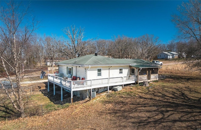 rear view of house with central AC unit and a deck