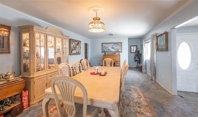 dining space with ornamental molding, carpet, baseboards, and a chandelier