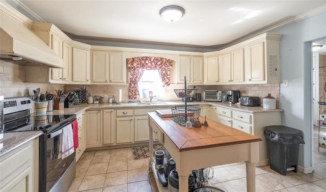 kitchen with custom exhaust hood, cream cabinetry, electric stove, and a sink