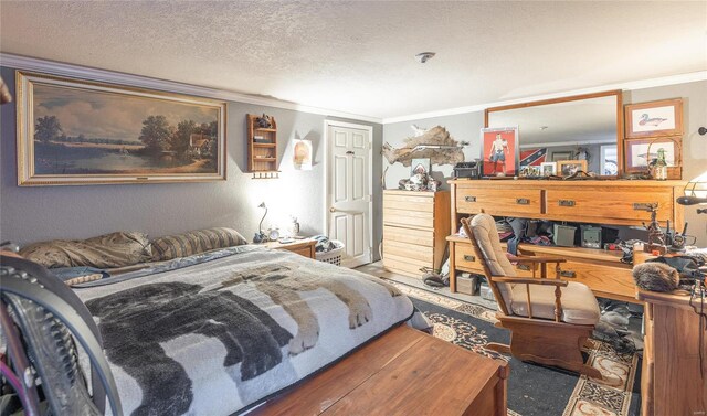 bedroom featuring a textured ceiling, wood finished floors, and crown molding