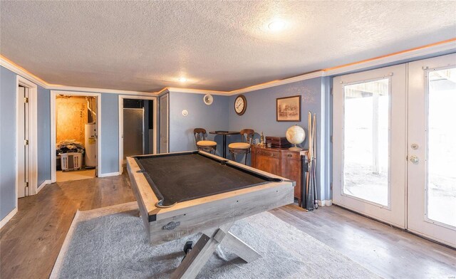 recreation room with billiards, wood finished floors, water heater, a bar, and french doors