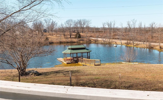 view of dock featuring fence and a water view