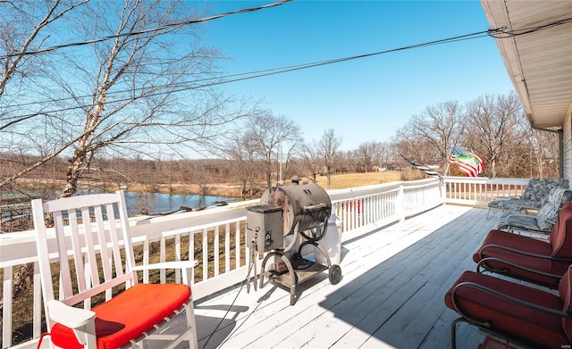 wooden deck with area for grilling and a water view