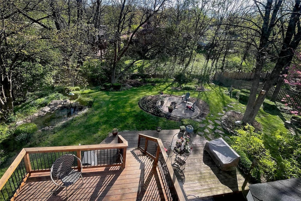 wooden terrace featuring a lawn and an outdoor fire pit