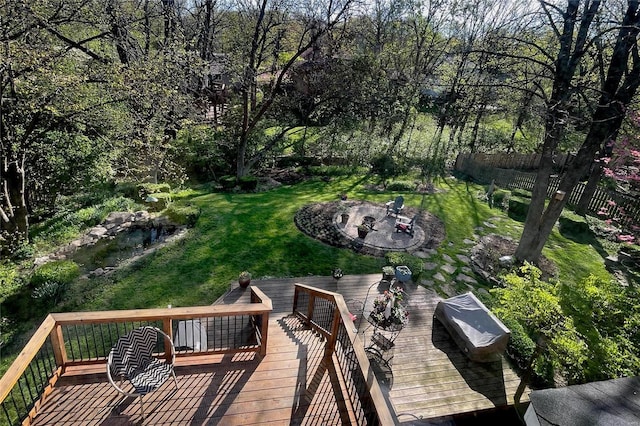 wooden terrace featuring a lawn and an outdoor fire pit