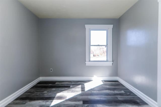 empty room with baseboards and wood finished floors