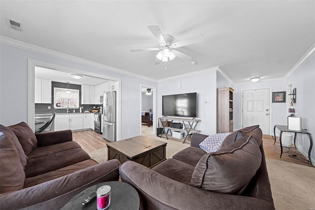 living room with ceiling fan, baseboards, visible vents, and crown molding