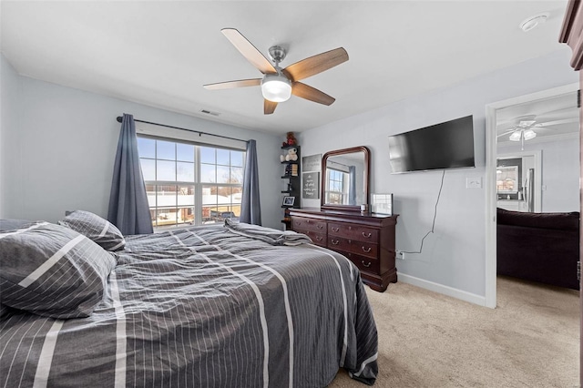 bedroom featuring visible vents, baseboards, a ceiling fan, and light colored carpet