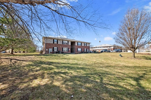 view of front facade featuring brick siding and a front lawn