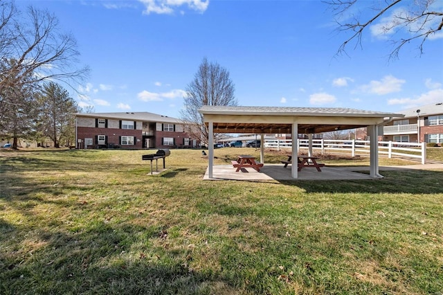 view of home's community featuring a patio, a lawn, and fence